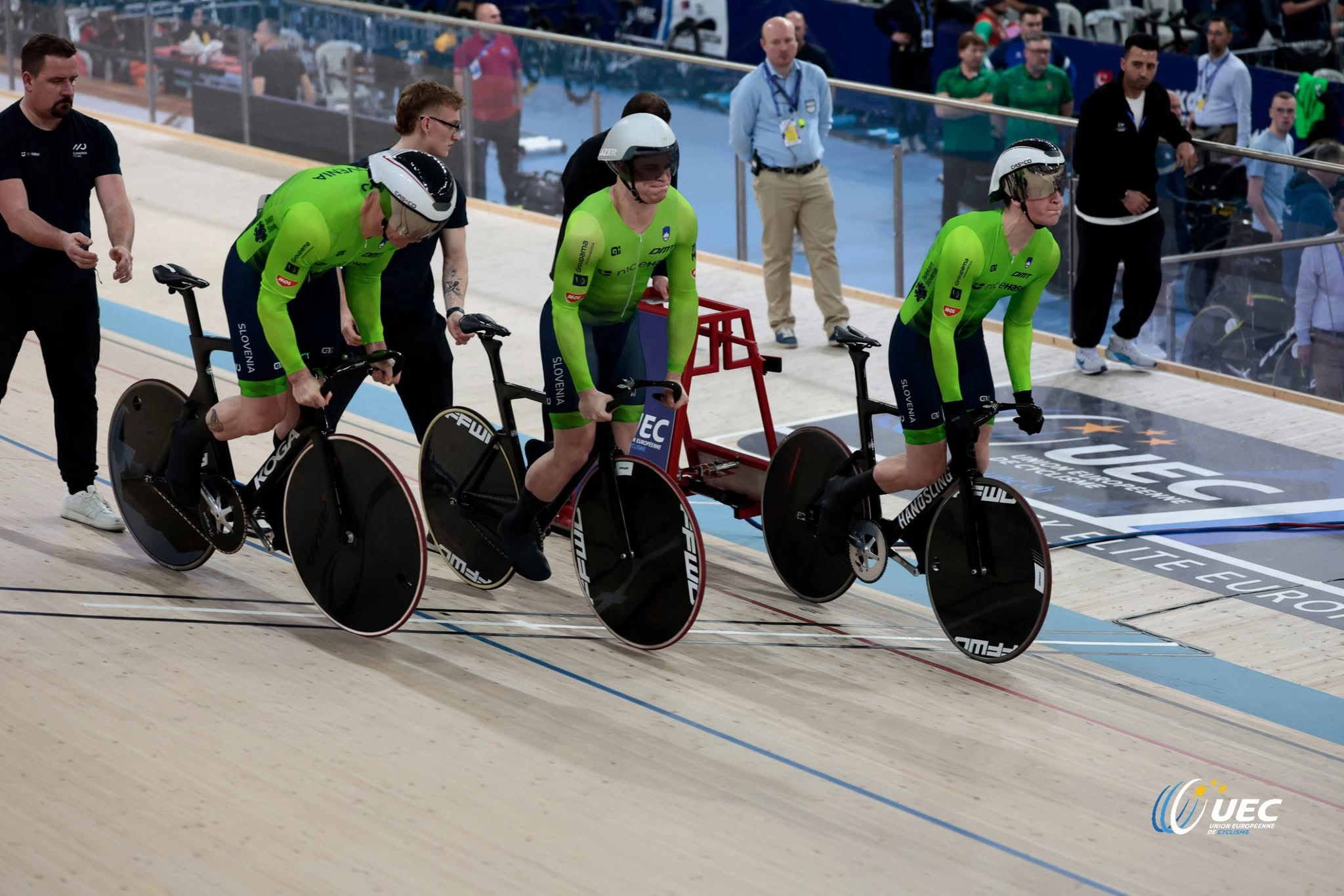 Trije kolesarji v slovenskih dresih na štartu ekipnega sprinta na velodromu